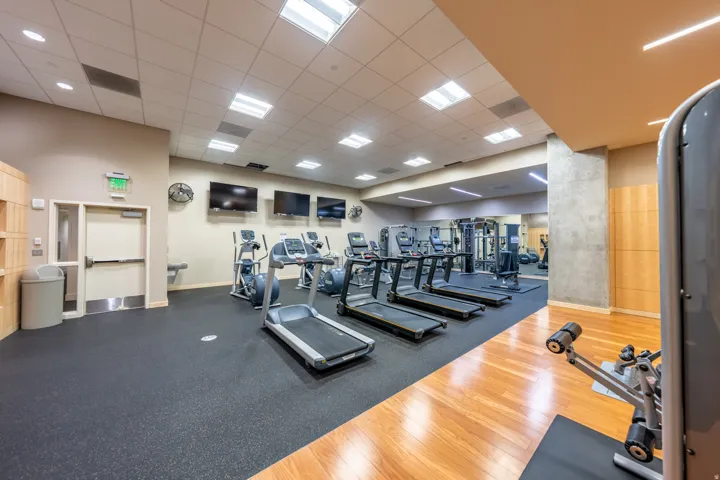 Fitness center featuring treadmills, elliptical machines, and weight training equipment