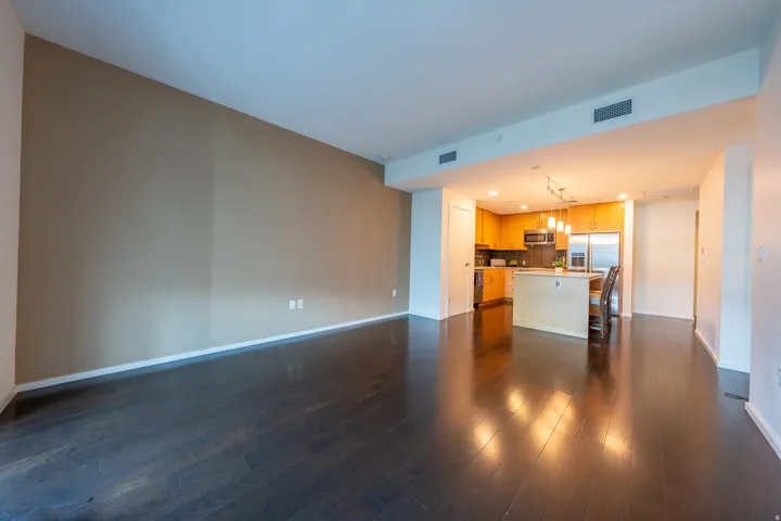 Dark wood-finish flooring, recessed lighting, wood cabinetry, stainless steel appliances, and a kitchen island with pendant lighting