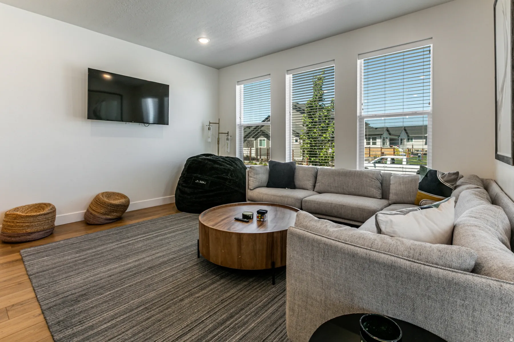 Living area featuring wood-finish flooring, recessed lighting, and white baseboards