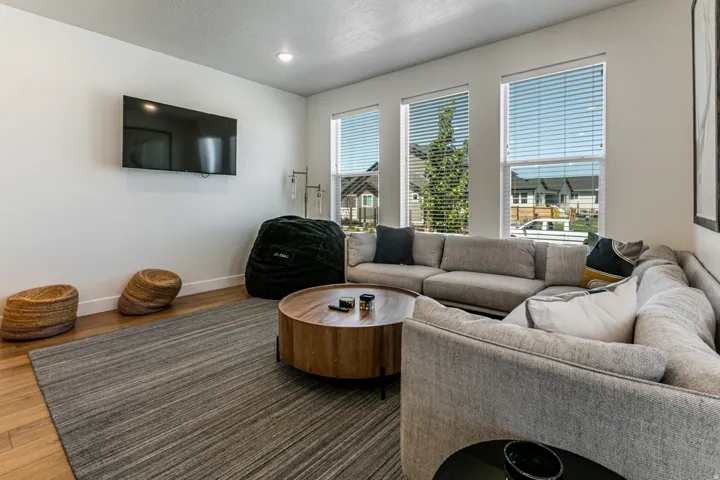 Living area featuring wood-finish flooring, recessed lighting, and white baseboards