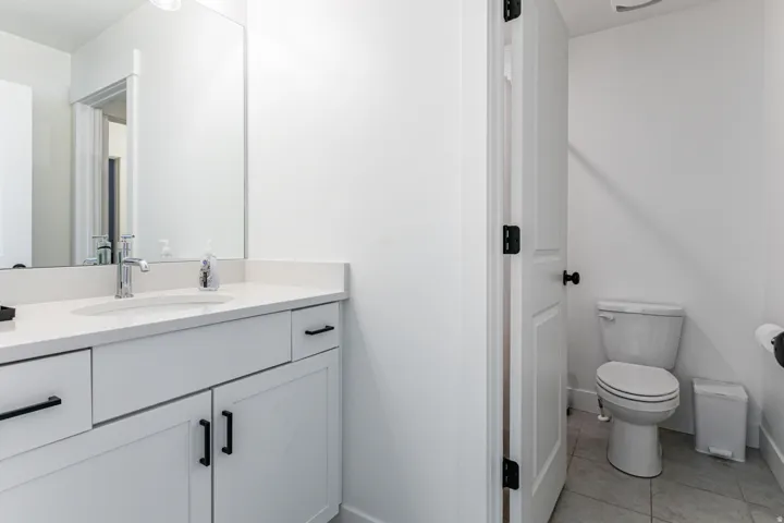 Modern vanity featuring a polished chrome faucet, under-mount sink, and quartz countertop