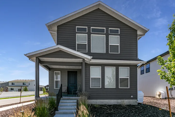 Contemporary two-story residence featuring dark gray horizontal siding and a covered front porch