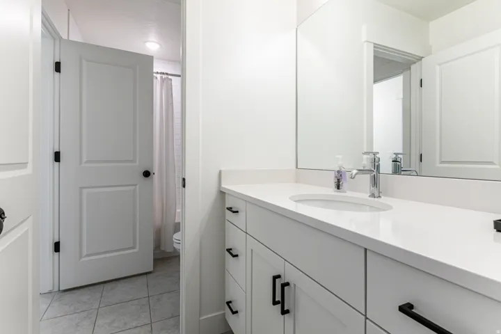 Modern vanity featuring a white countertop, undermount sink, and chrome faucet