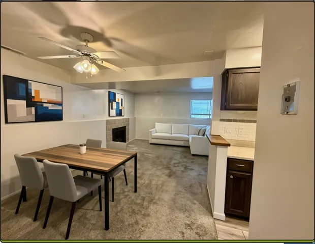 Open-concept living space featuring a fireplace with stone surround, dining room conveniently located adjacent to kitchen and living room
