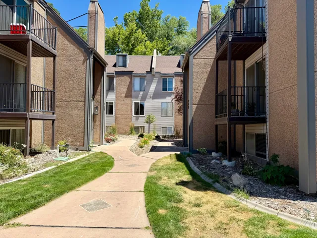 Concrete walkway bordered by manicured lawns and landscaping