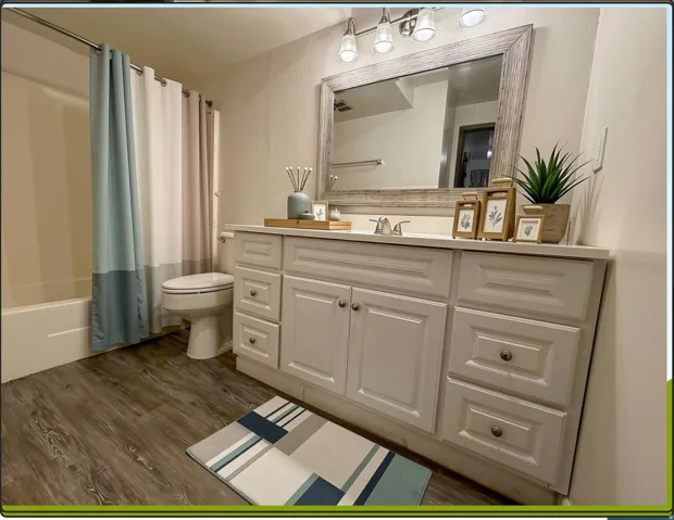 Bathroom with vanity, large mirror and bath/shower combination