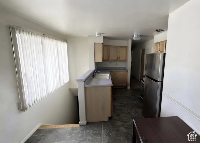 Kitchen area featuring light wood-finish cabinetry and stainless steel appliances