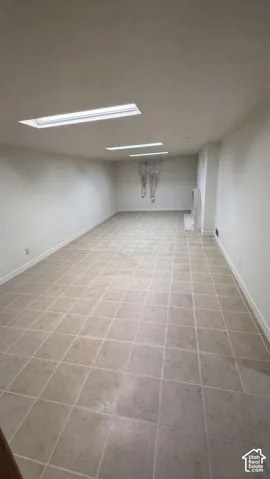 Expansive room featuring recessed lighting, tile flooring, and a stone-surround hearth