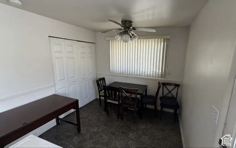 Dining area featuring patterned floor tile, a ceiling fan with integrated lighting, and a window with blinds