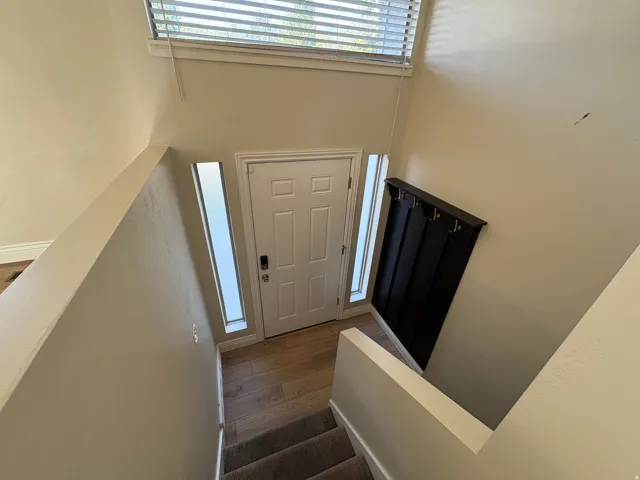 Entryway featuring a white paneled door with a keyless entry system, flanked by two vertical translucent windows