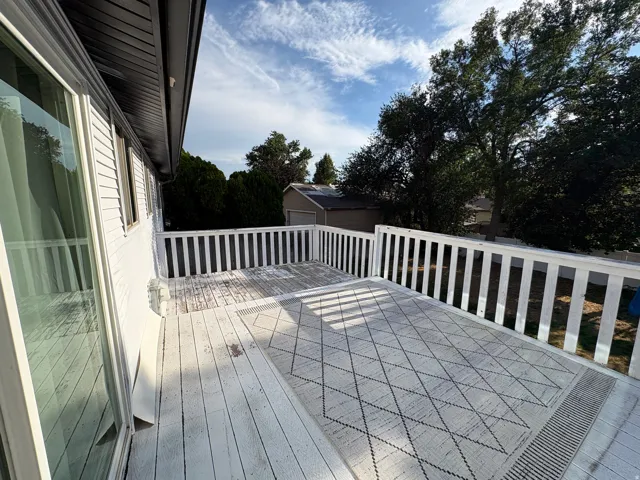 Spacious outdoor deck featuring painted wood flooring and white railing