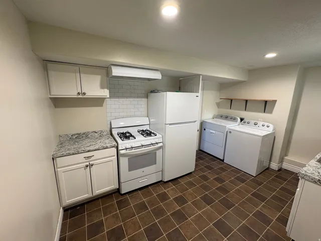 Kitchenette featuring white cabinetry, subway tile backsplash, and a gas range