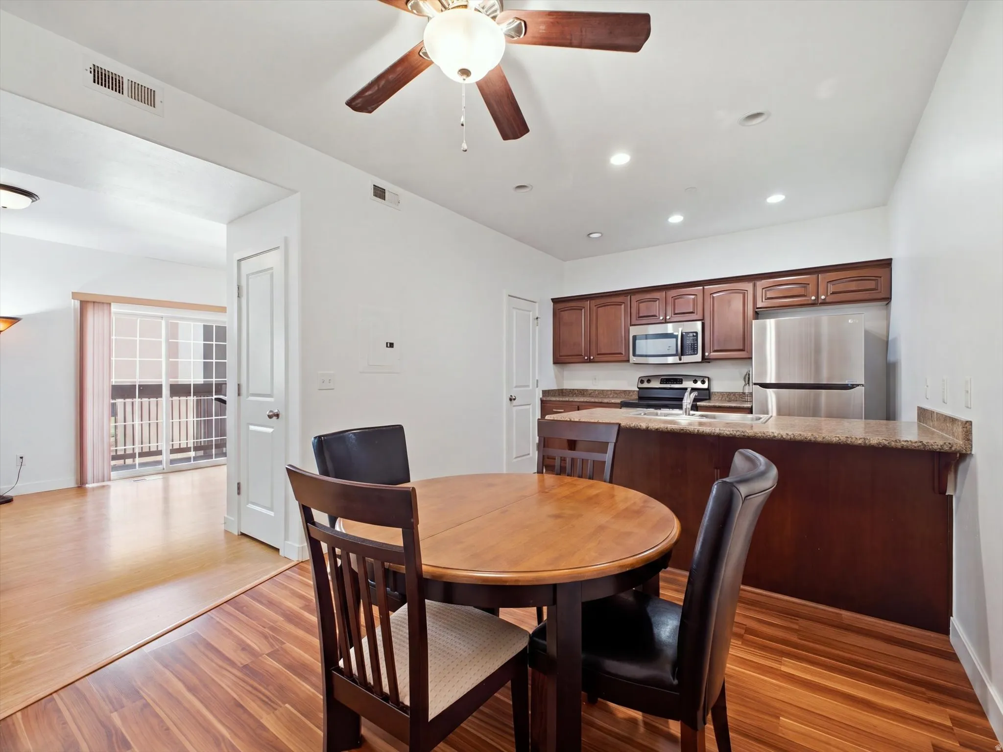 Wood-finish flooring, recessed lighting, and a ceiling fan with light fixture