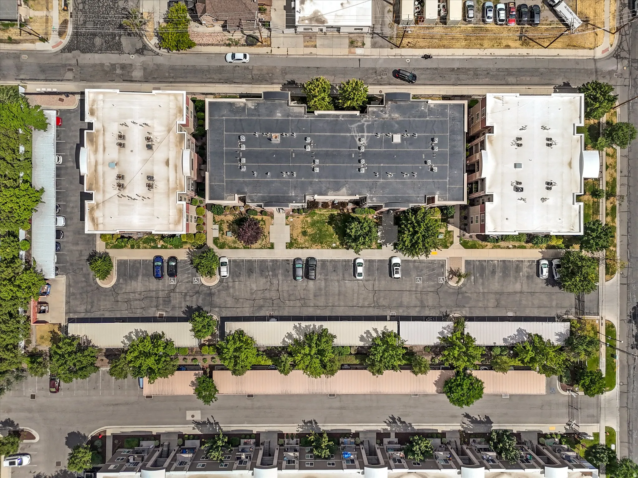 Aerial overview of a multi-building complex featuring extensive paved parking areas