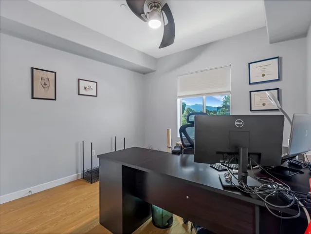 Neutral wall paint, wood-finish flooring, and a large window with mountain scenery