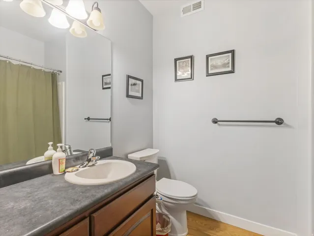 Bathroom vanity with a dark countertop, an integrated sink, and a chrome faucet