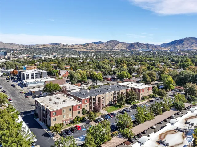 Multi-story residential buildings with balconies, surface parking, and covered parking structures