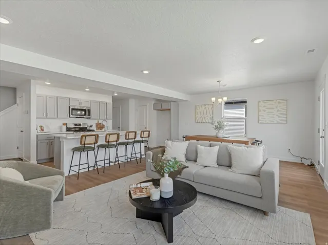 Open-concept living area featuring wood-finish flooring, recessed lighting, and a white color palette
