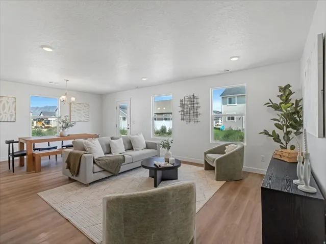 Open-concept living space featuring wood-finish flooring, recessed lighting, and multiple windows