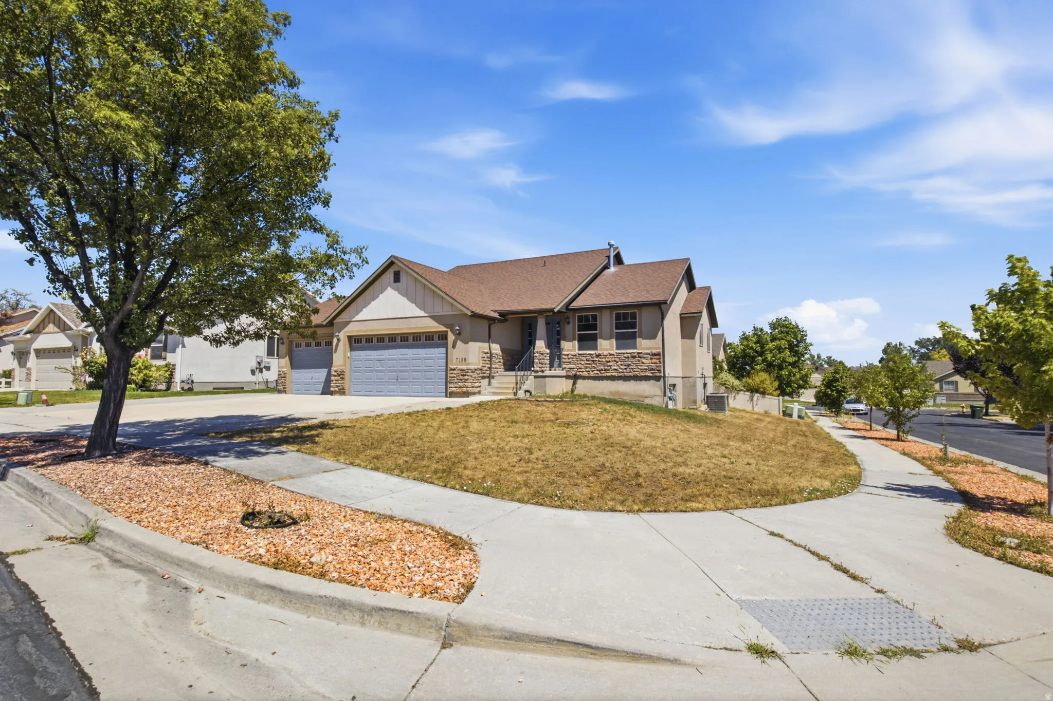 Ranch-style residence featuring a prominent front gable and a combination of stucco and stone veneer siding