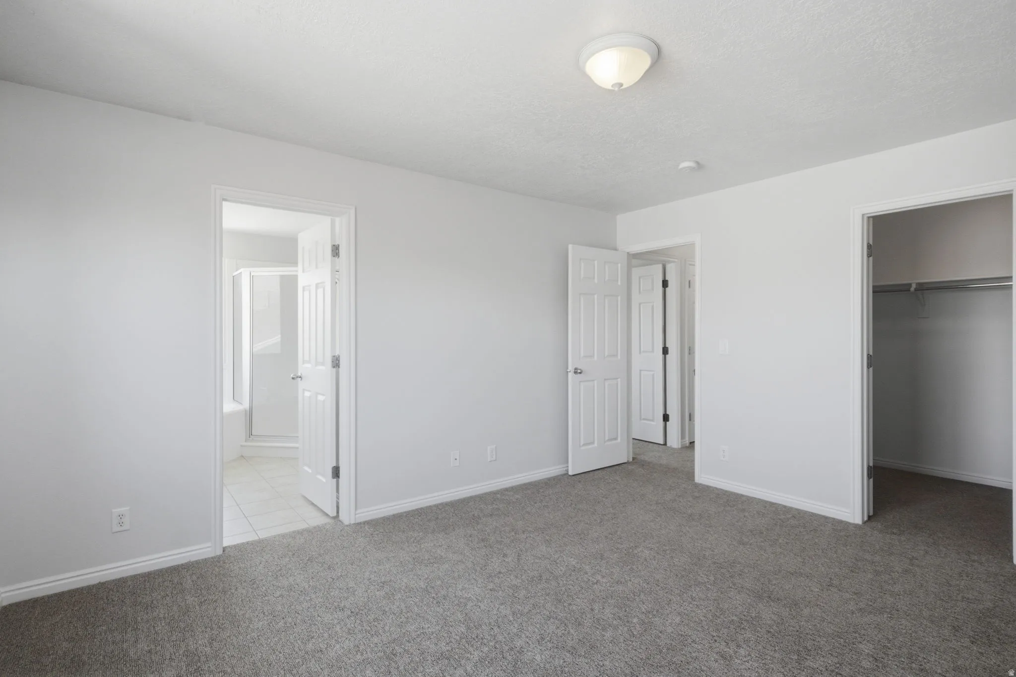 Carpeted room with light gray walls, featuring a flush-mount ceiling light