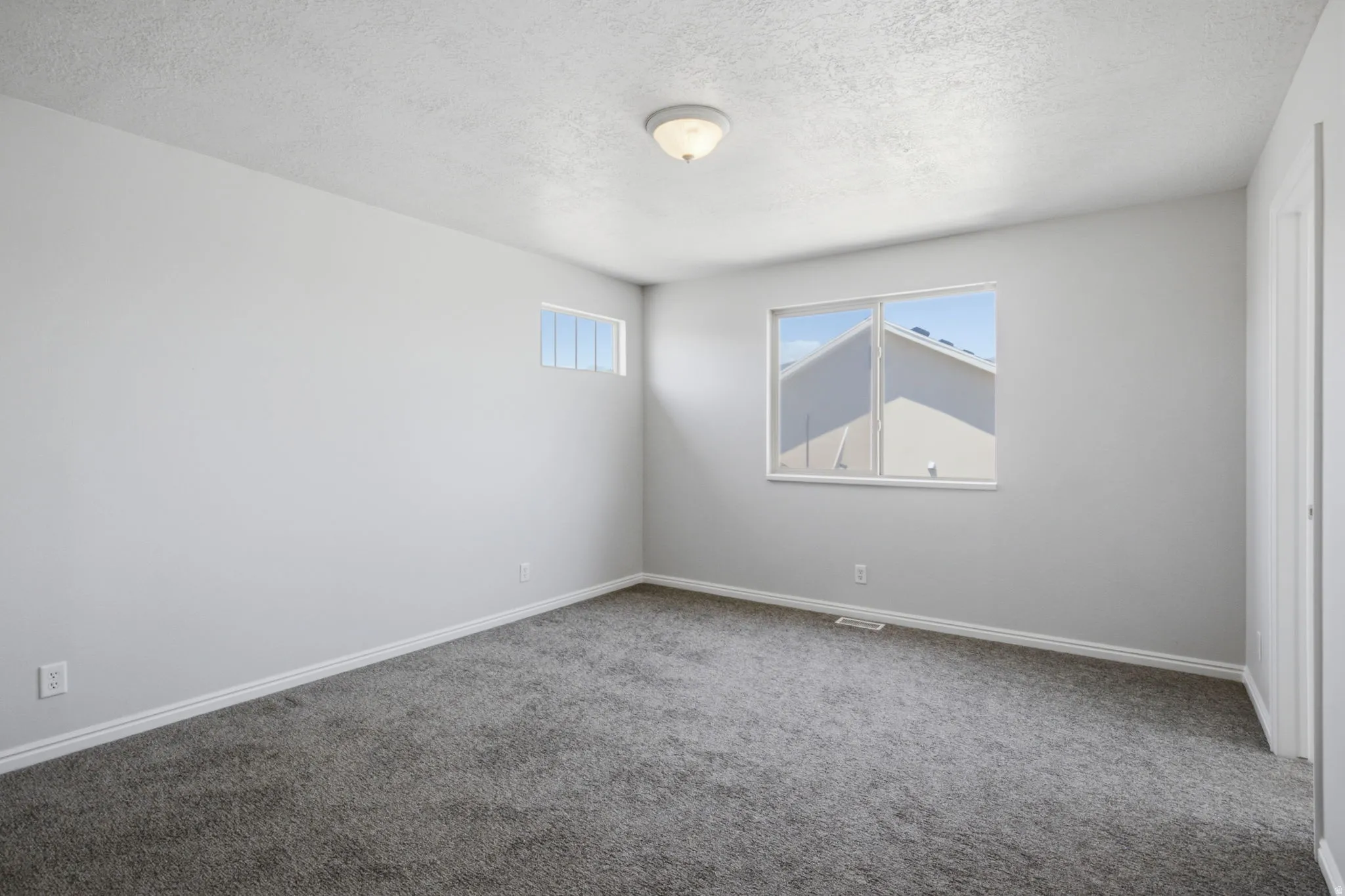 Carpeted room featuring light gray walls, white trim, and a semi-flush mount ceiling light