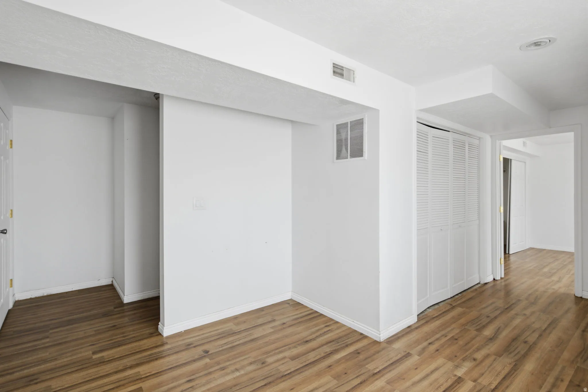 Interior space featuring wood-finish flooring, white walls, and white trim