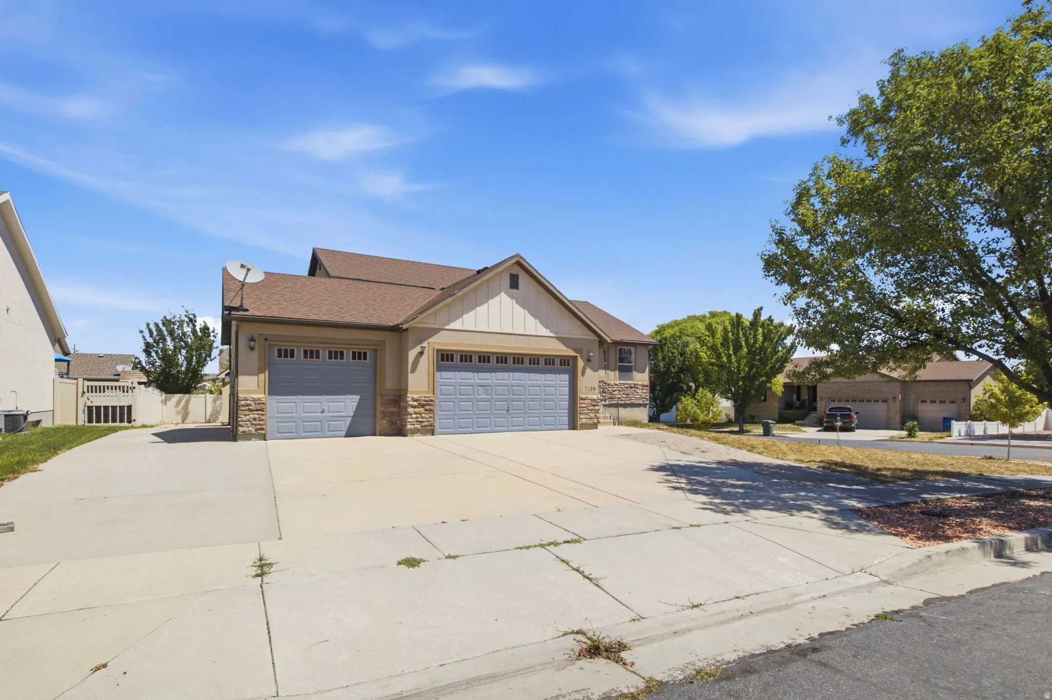 Two-story residence featuring a two-car garage and a single-car garage, both with paneled doors