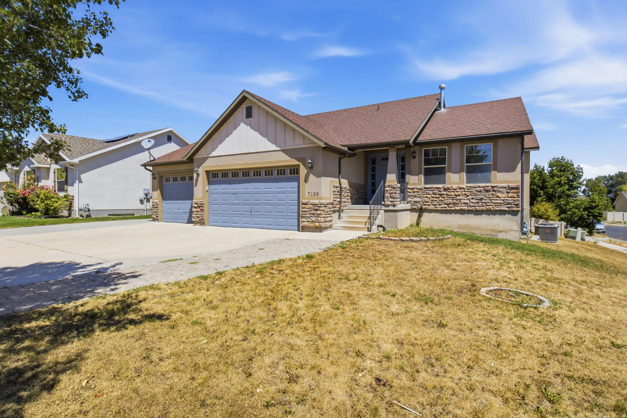 Ranch-style exterior featuring a multi-tone facade with stone and stucco finishes
