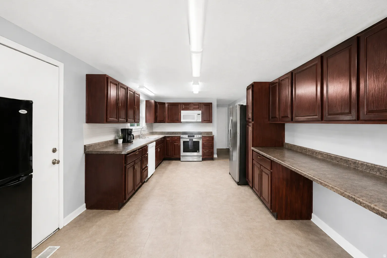 Expansive kitchen featuring wood-finish cabinetry and textured countertops