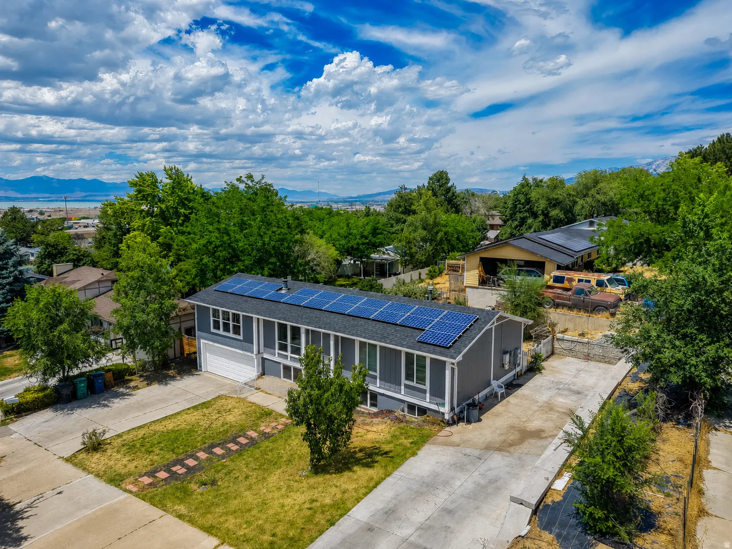 Contemporary residence featuring a dark gray exterior, white trim, and a prominent solar panel array