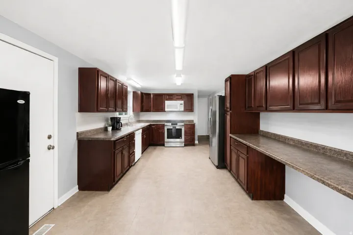 Expansive kitchen featuring wood-finish cabinetry and textured countertops