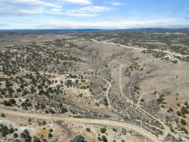 Expansive, arid landscape featuring rolling hills and sparse, low-lying vegetation