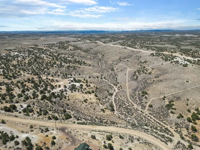 Expansive, arid landscape featuring rolling hills and sparse, low-lying vegetation