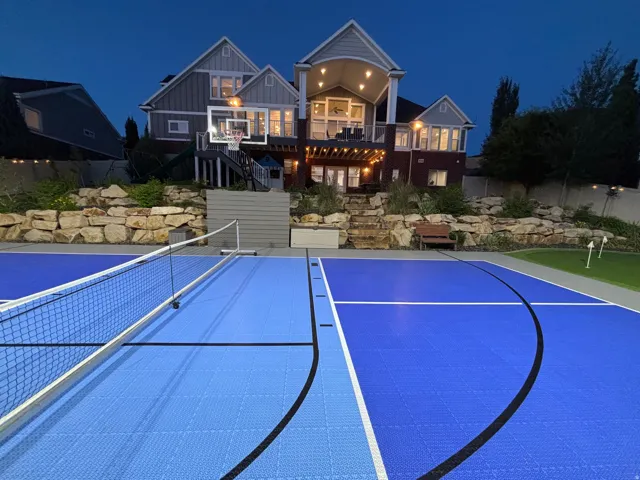 Multi-sport court featuring vibrant blue modular surfacing and a net system