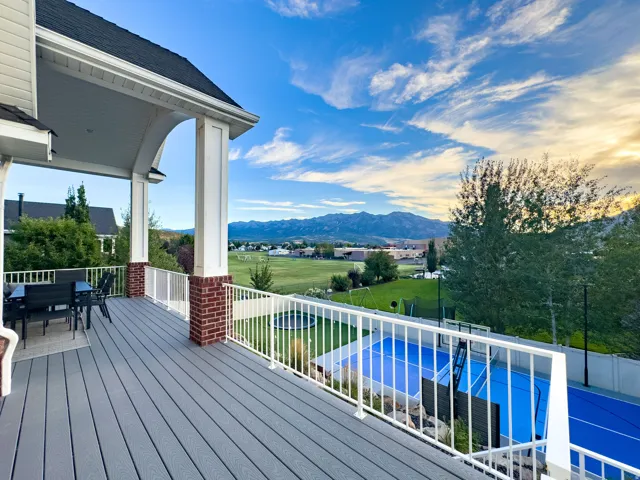 Expansive deck with composite decking, white railing, and brick column accents