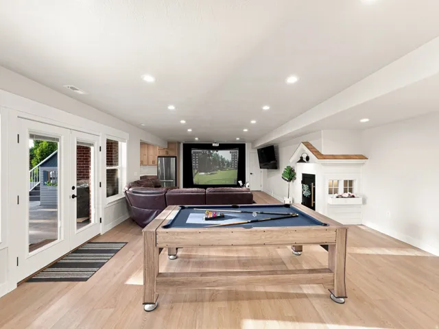 Recessed lighting illuminates the open-concept room with light wood-finish flooring