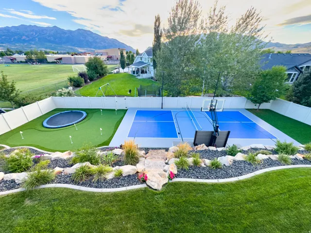 Multi-sport court, putting green with integrated trampoline, and mountain backdrop