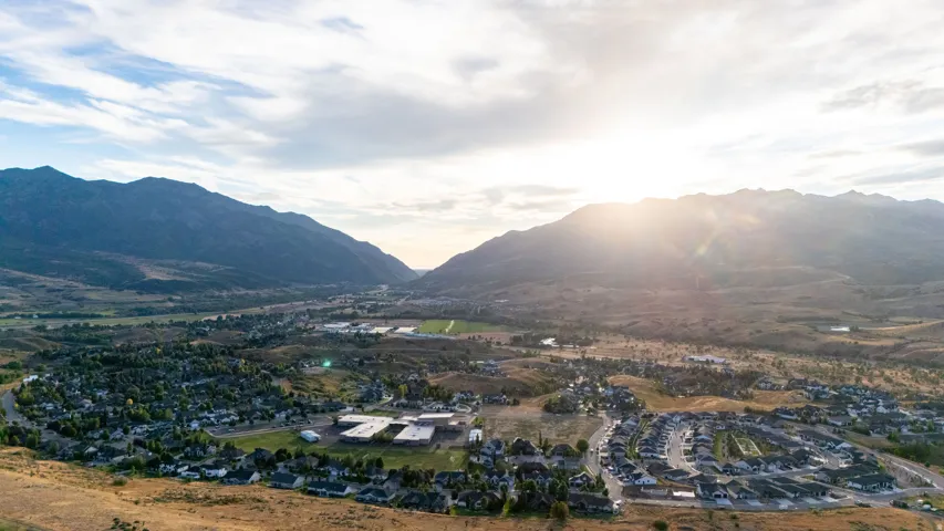 Mountainous backdrop, residential community, valley setting, scattered trees, expansive terrain