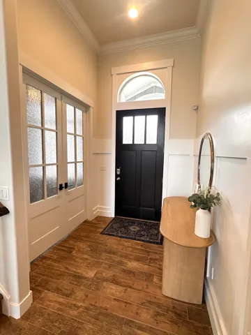 Entryway featuring Tile flooring, wainscoting, and crown molding