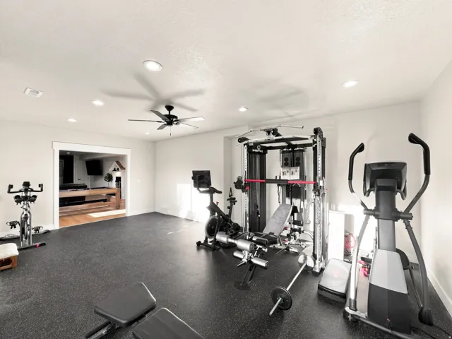 Spacious room featuring recessed lighting, a ceiling fan, and durable dark-tone flooring