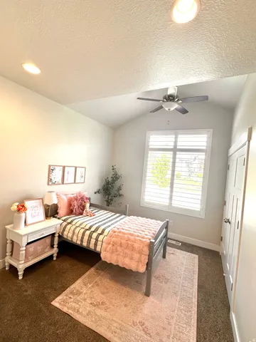 Vaulted ceiling room featuring recessed lighting, a ceiling fan, a window with plantation shutters, and a white paneled door