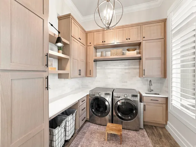 Light wood-finish cabinetry, built-in shelving, white countertop, undermount sink, and wood-finish flooring