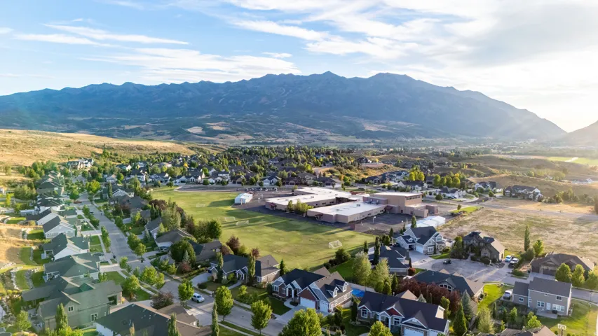 Residential community with established streets, mature trees, and mountain scenery