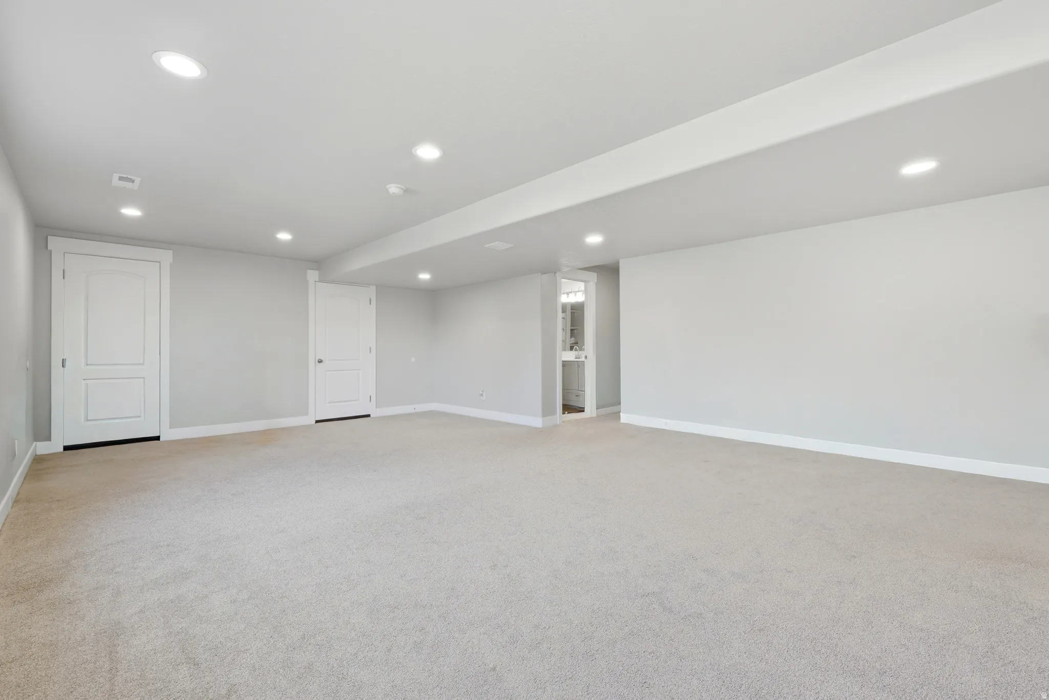 Expansive carpeted room featuring recessed lighting and a neutral color palette