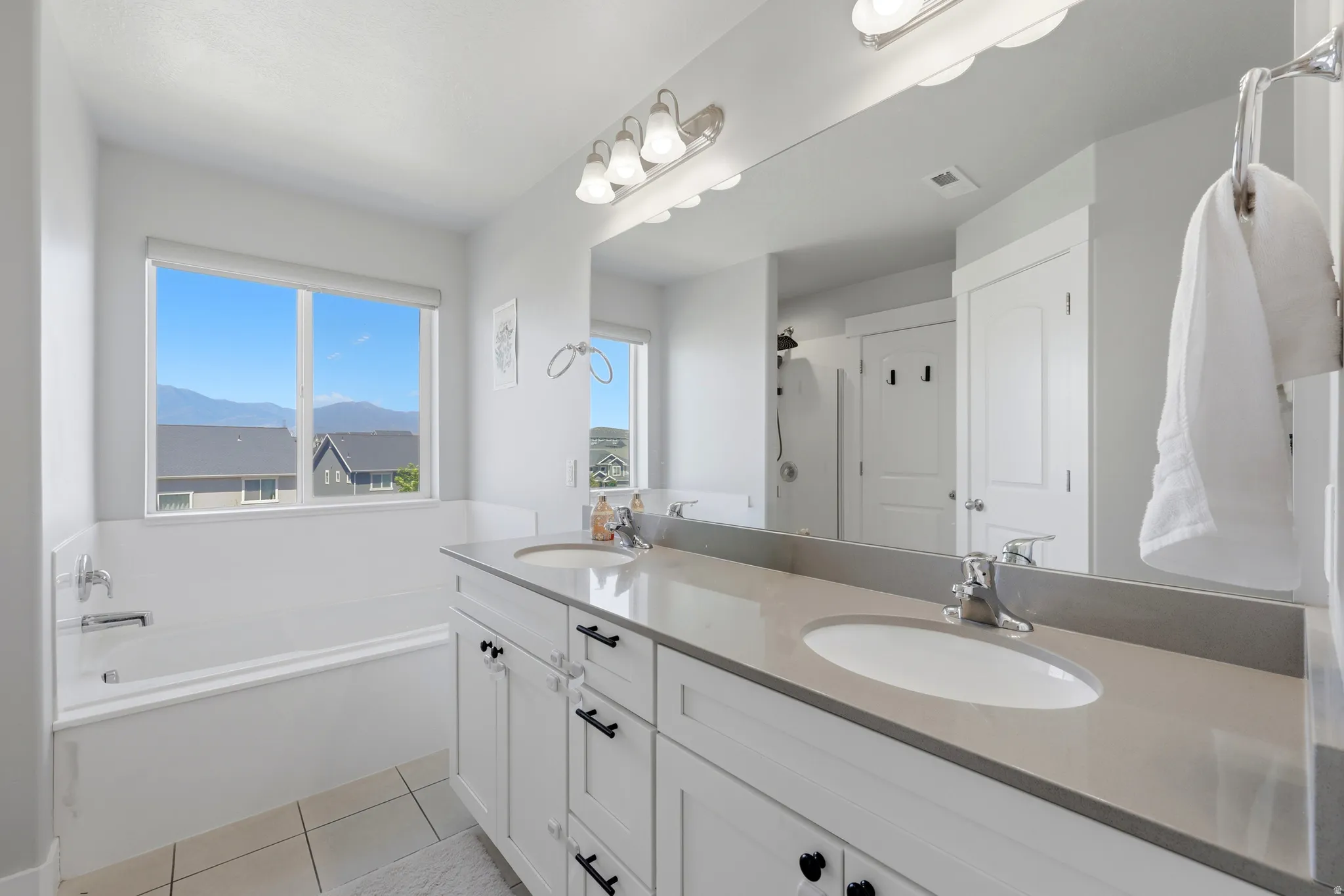 Spacious bathroom featuring a double vanity with stone countertops, undermount sinks, and ample storage