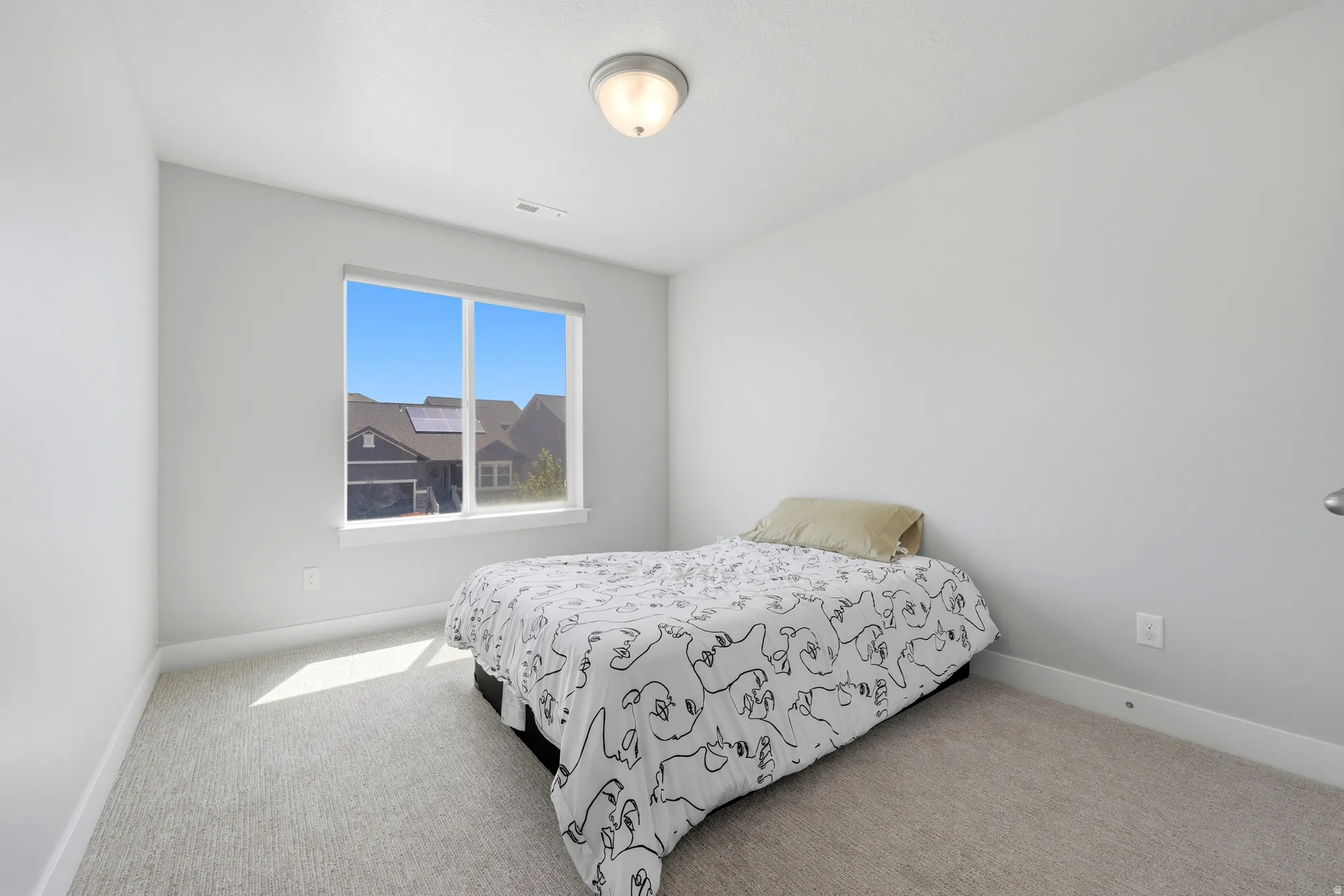 Carpeted room featuring a large window, neutral wall paint, and a semi-flush ceiling light fixture
