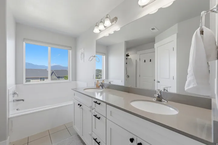Spacious bathroom featuring a double vanity with stone countertops, undermount sinks, and ample storage