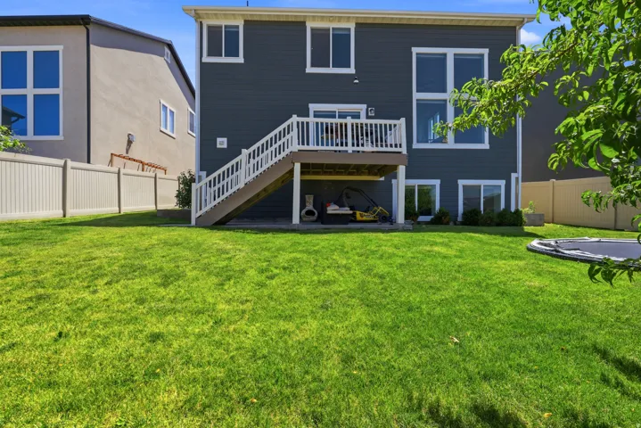 Expansive green lawn with a multi-level deck and patio