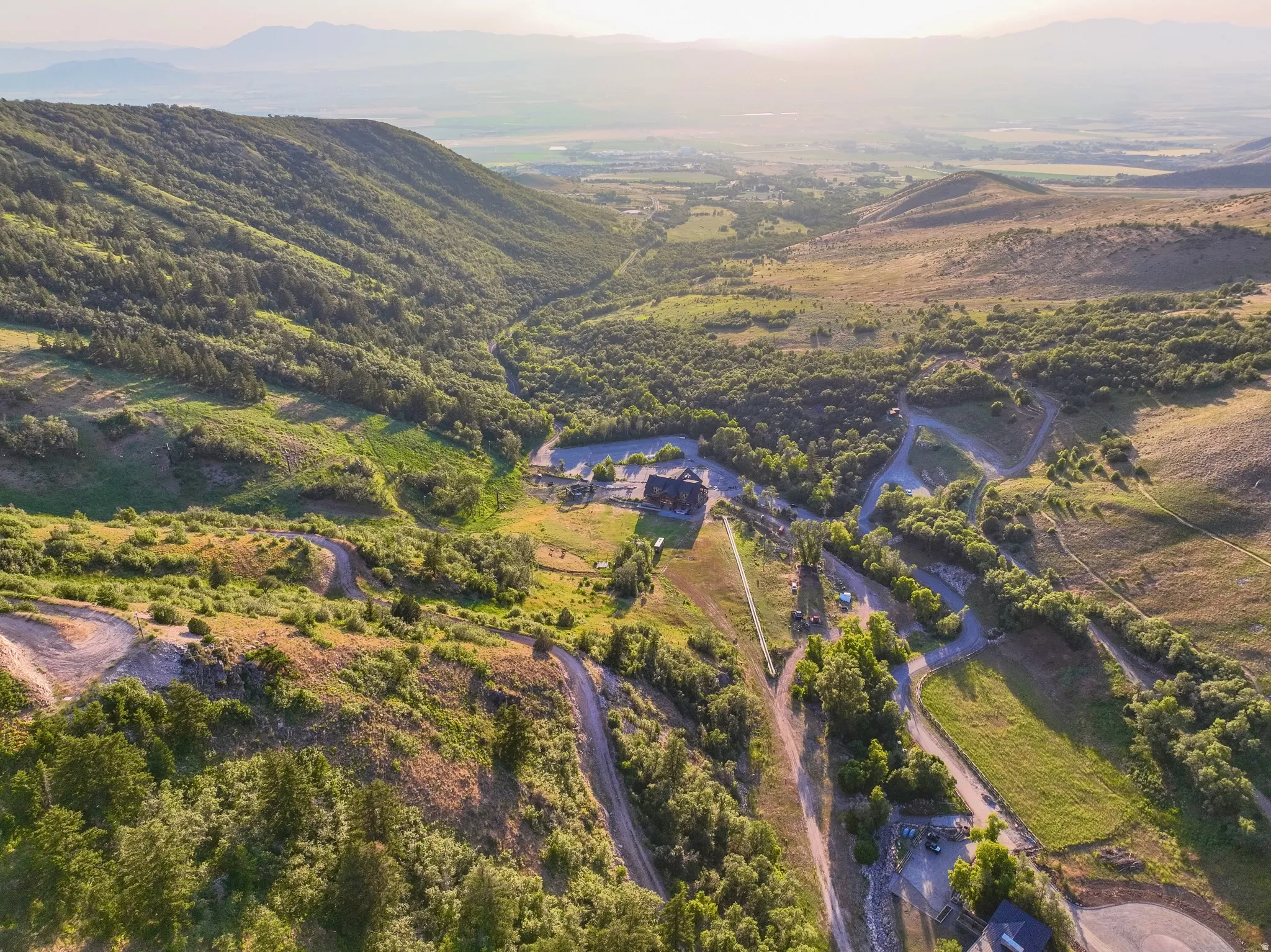 Expansive mountain property featuring a large lodge-style building, multiple winding paths, and abundant natural foliage